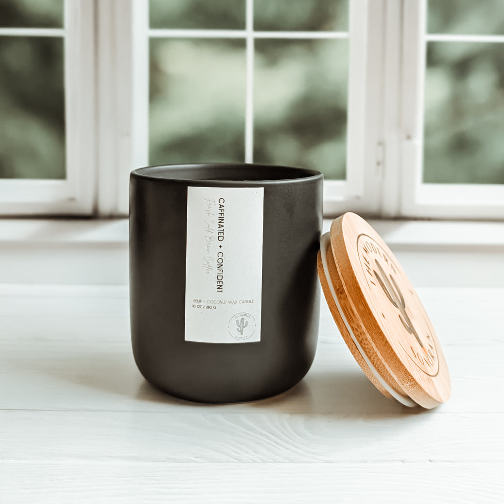 Caffeinated & Confident Coffee Hemp and Coconut wax candle. One of the candles from our modern farmhouse collection, this Cold Brew Coffee scented clean ingredient, non-toxic candle is soy free, paraffin free, carcinogen free, mutagen free, and contain no hormone disruptors. Sustainably sourced ingredients. In a 10 oz. charcoal Ceramic jar with bamboo lids. Side view shown.