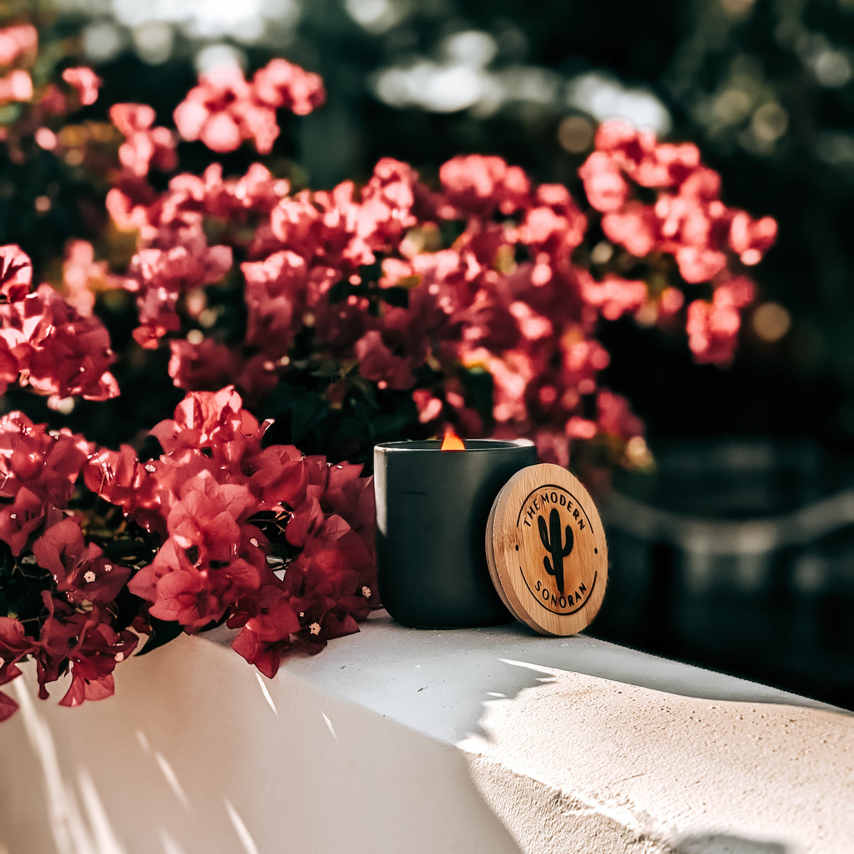 a Natural Attraction candle The Modern Sonoran with flowers in the background