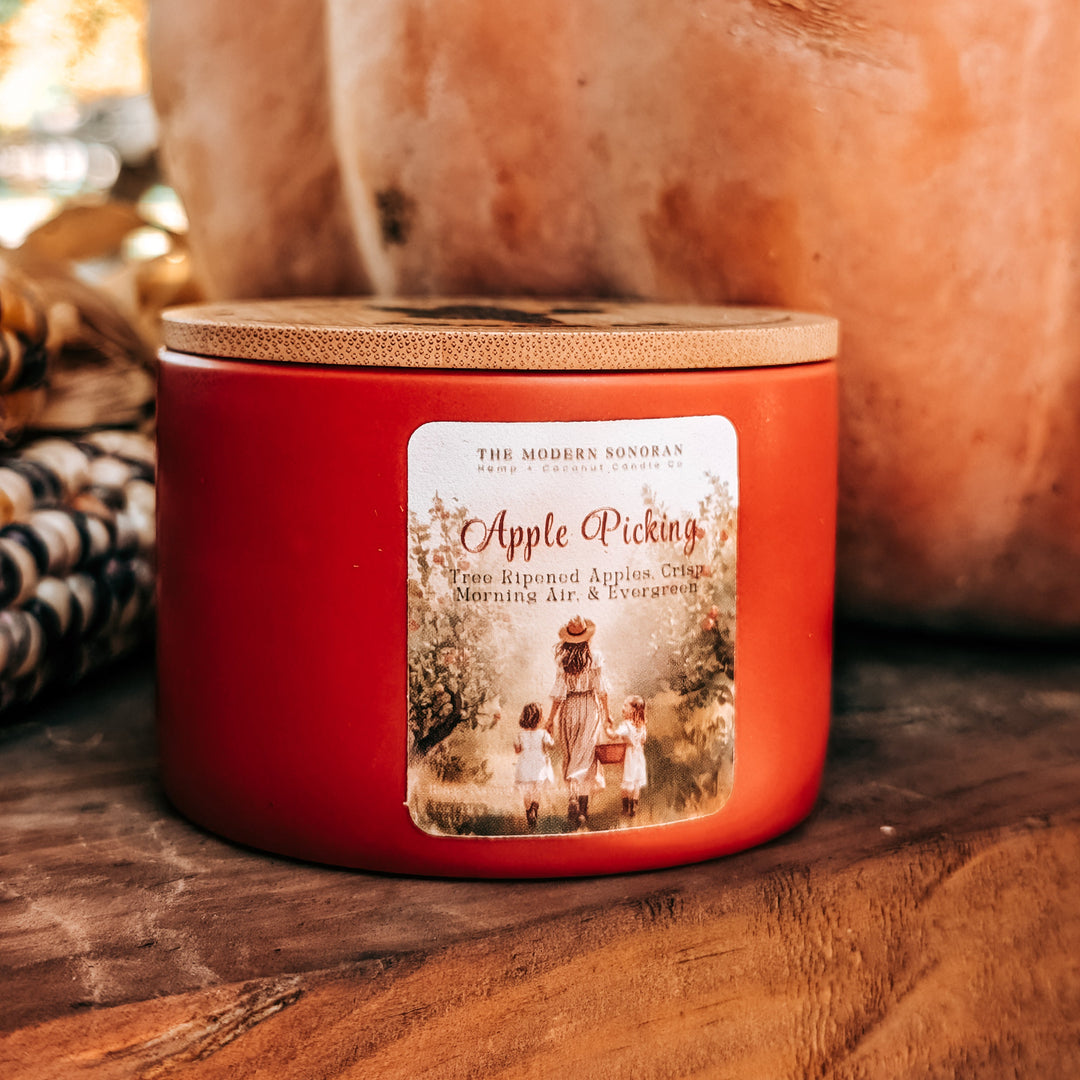 Red candle labeled 'Apple Picking' with pumpkins in the background