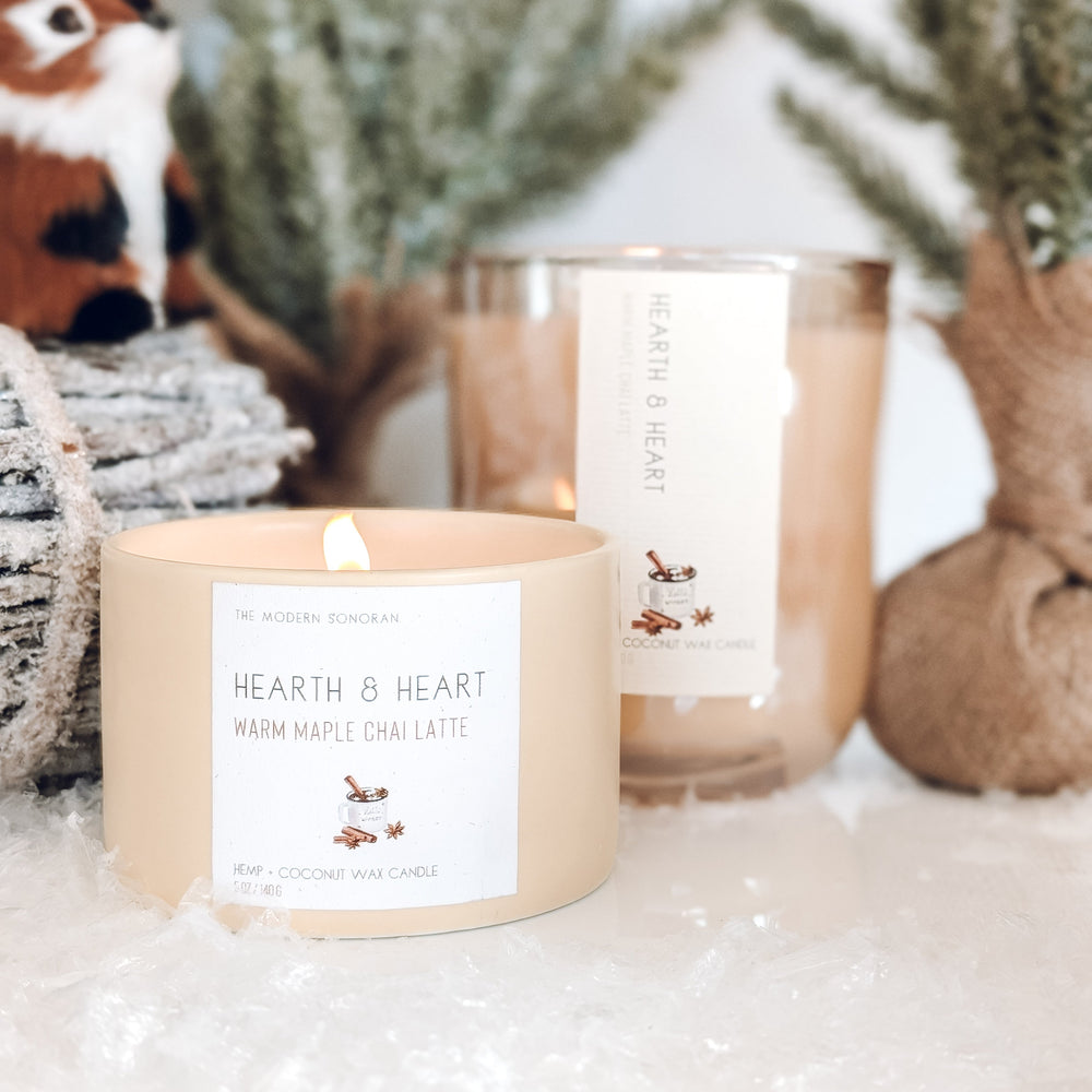 Candle labeled 'Hearth & Heart' with decorative elements in the background