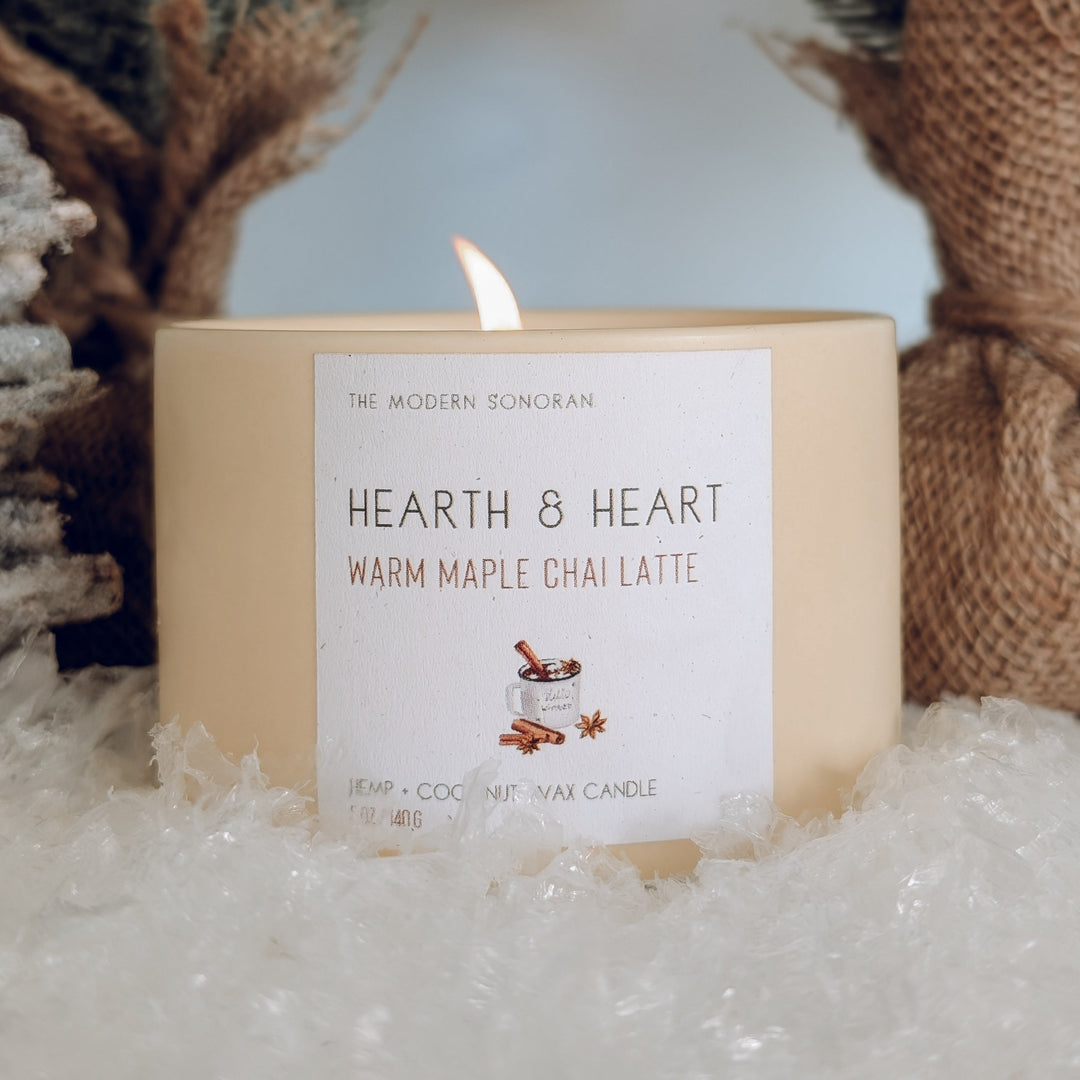 Candle labeled 'Hearth & Heart' with decorative elements in the background