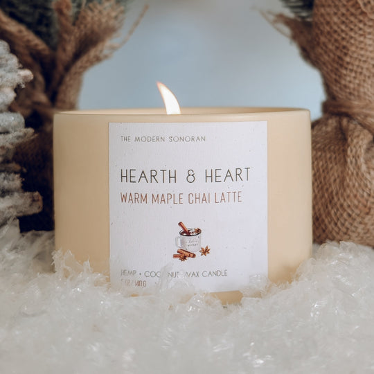 Candle labeled 'Hearth & Heart' with decorative elements in the background