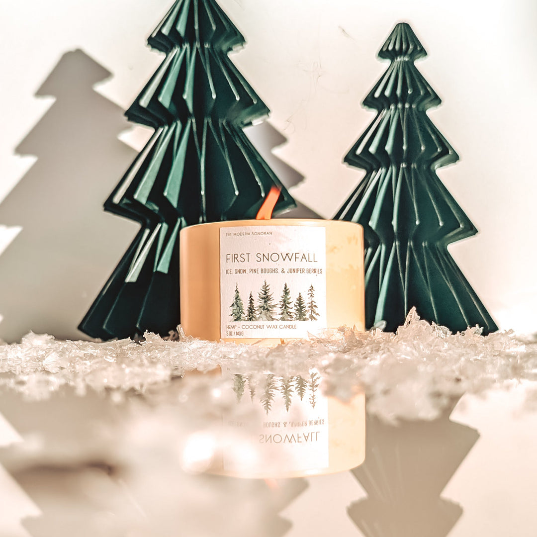 Decorative setup with Christmas trees and a fox figurine on a white surface.