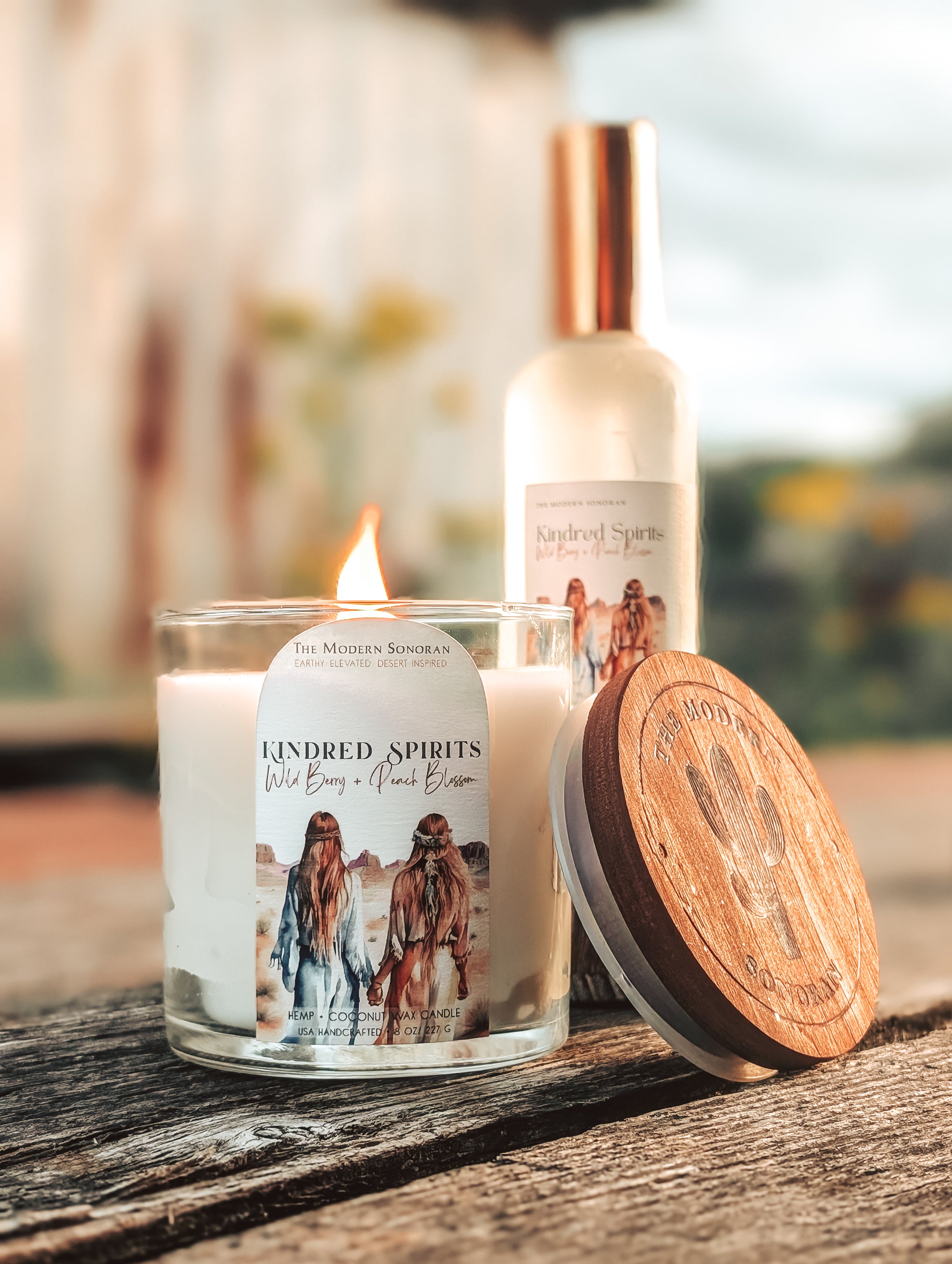 picture of a 'Kindred Spirits' Candle and bottle  branding on a wooden surface.