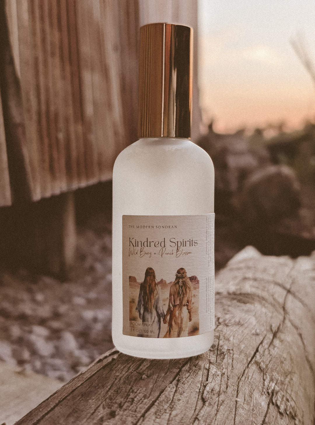 A Kindred Spirits Room Spray: (Limited Edition) from The Modern Sonoran on a log.