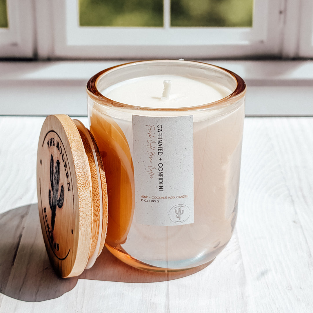 an EXTREME close up shot of a Caffinated and Confident candle in a glass jar on a windowsill