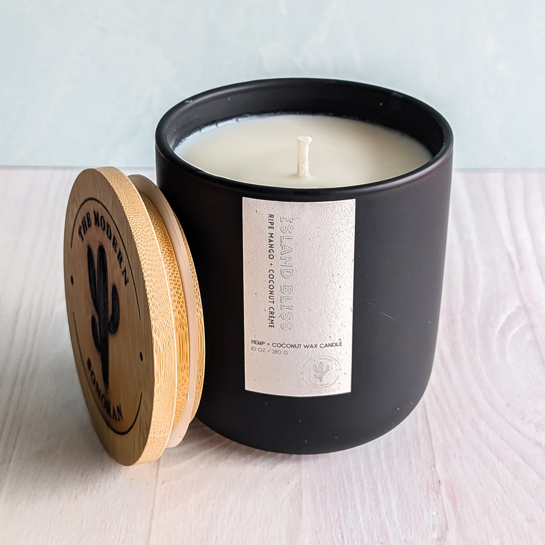 An non-toxic Island Bliss Candle in a black ceramic jar