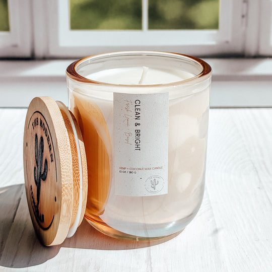 An EXTREMELY close up shot of a Clean and bright candle in a glass jar on a windowsill